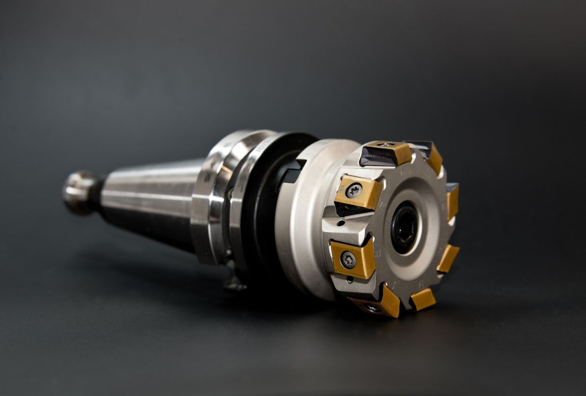 Metal machining tool holder with gold cutting inserts on a dark background