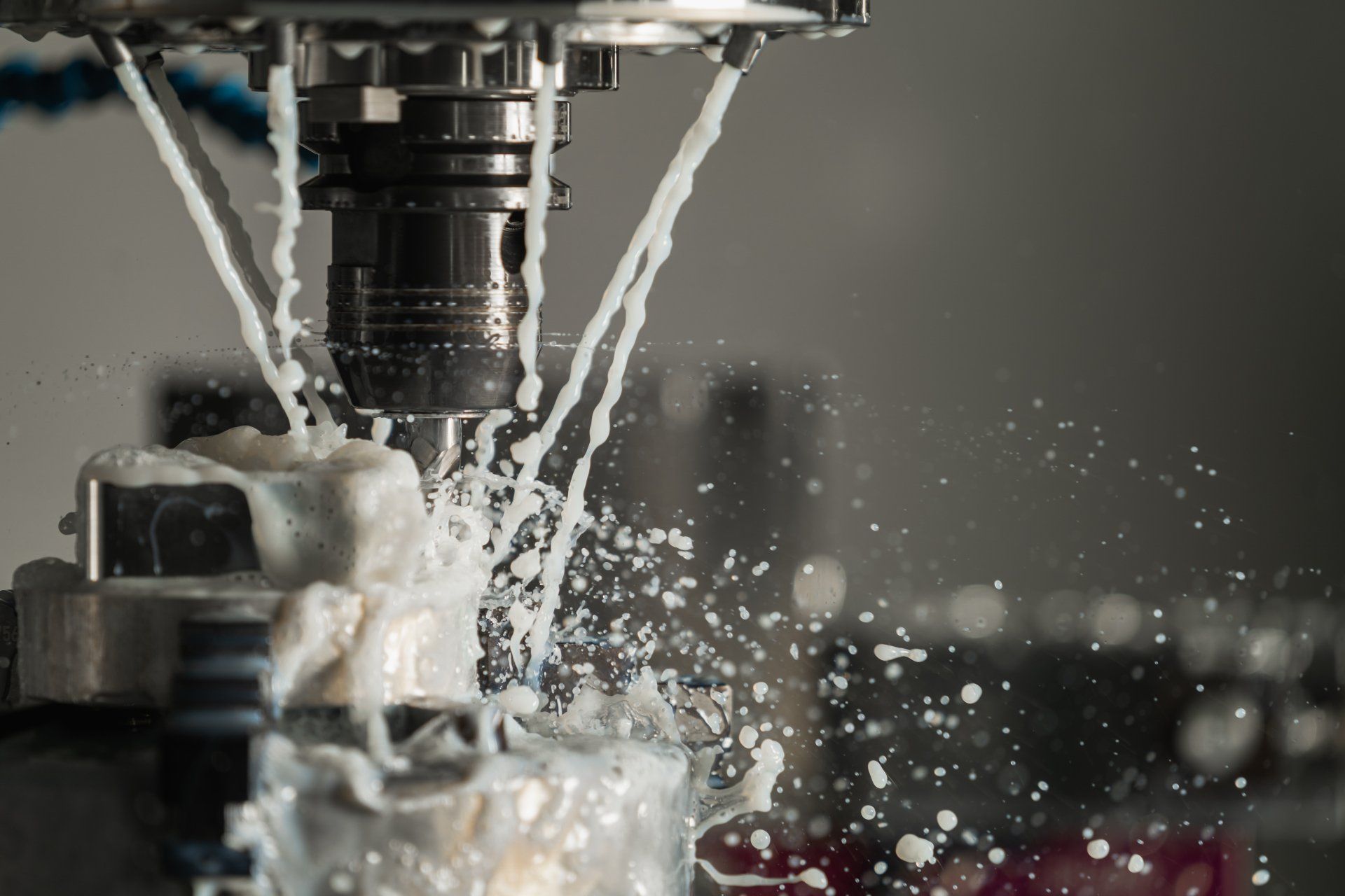 Metal machine spraying coolant over a workpiece in a CNC machining setup